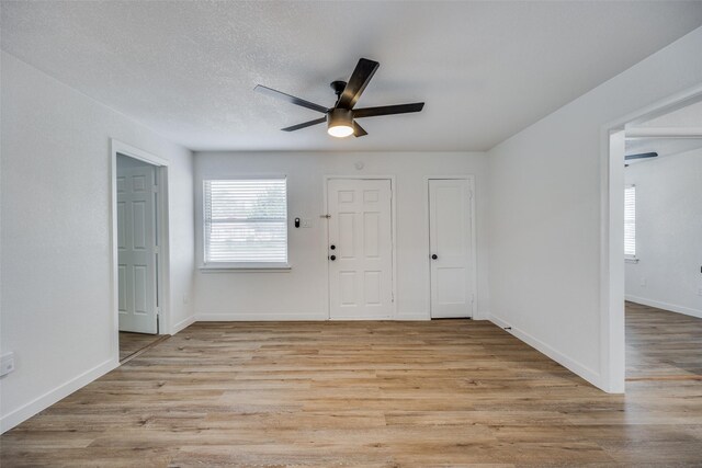 foyer entrance featuring ceiling fan, a textured ceiling, and light wood-type flooring