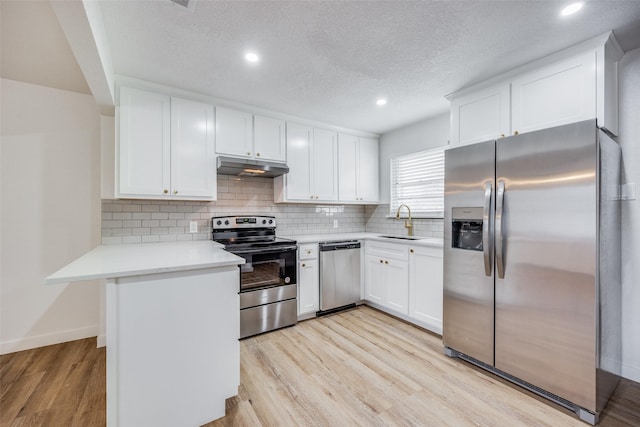 kitchen with sink, white cabinets, light hardwood / wood-style floors, and appliances with stainless steel finishes