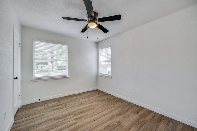 unfurnished room with ceiling fan, light hardwood / wood-style flooring, and a textured ceiling