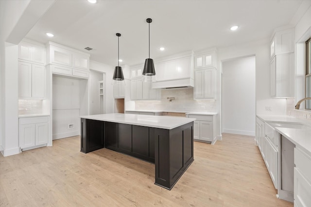 kitchen with decorative backsplash, white cabinetry, and light hardwood / wood-style floors