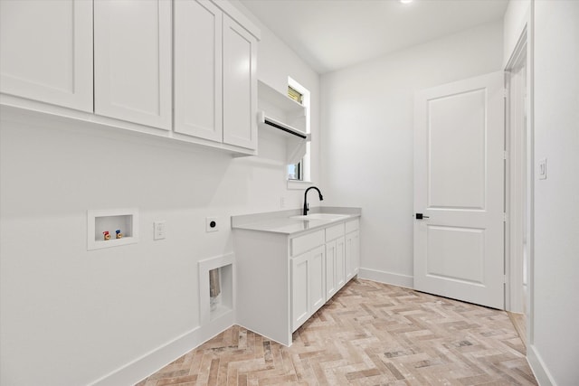 washroom with sink, cabinets, hookup for an electric dryer, hookup for a washing machine, and light parquet flooring