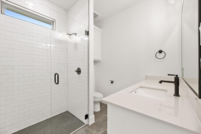 bathroom with tile patterned flooring, vanity, a shower with shower door, and toilet