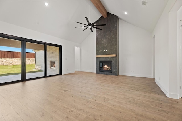 unfurnished living room with beamed ceiling, high vaulted ceiling, light hardwood / wood-style flooring, and a tiled fireplace