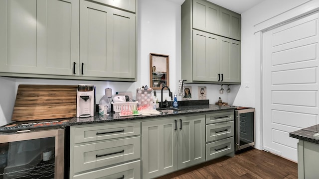 bar featuring dark hardwood / wood-style floors, wine cooler, dark stone countertops, and sink