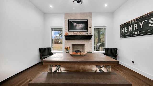 office area with dark hardwood / wood-style flooring and a brick fireplace