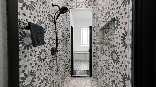 bathroom featuring walk in shower and tile walls