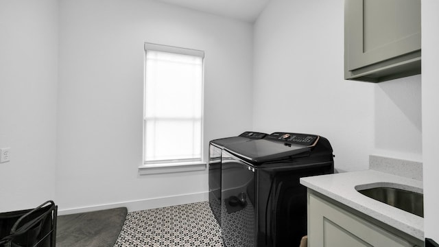 laundry room with cabinets, washer and dryer, and sink