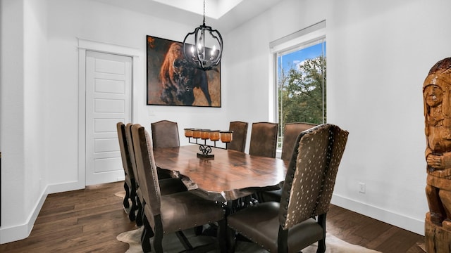 dining space featuring dark hardwood / wood-style flooring and an inviting chandelier