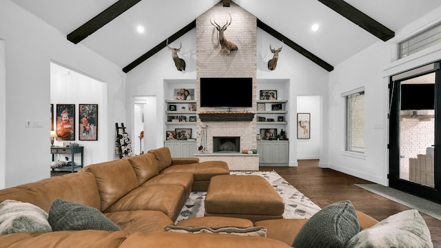 living room with beamed ceiling, built in shelves, a large fireplace, and dark wood-type flooring