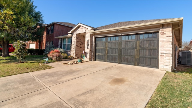 view of front of property with a garage, a front lawn, and central air condition unit