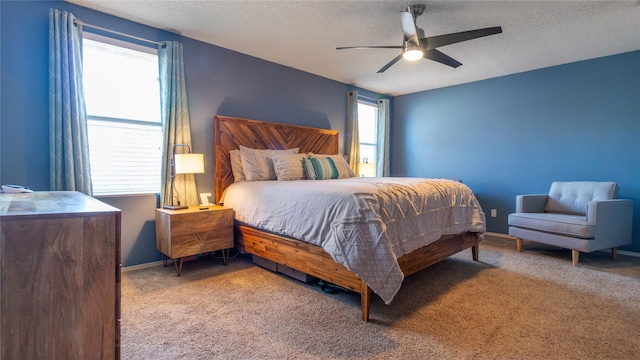 bedroom with a textured ceiling, ceiling fan, and carpet