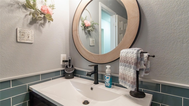 bathroom with decorative backsplash, tile walls, and vanity