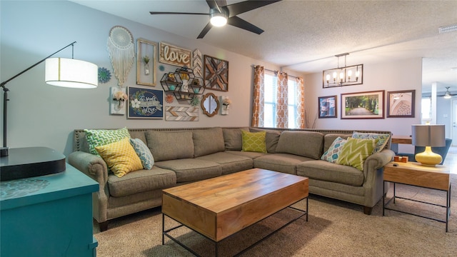 carpeted living room featuring ceiling fan with notable chandelier and a textured ceiling