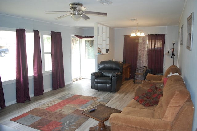 living room with ceiling fan with notable chandelier and light wood-type flooring