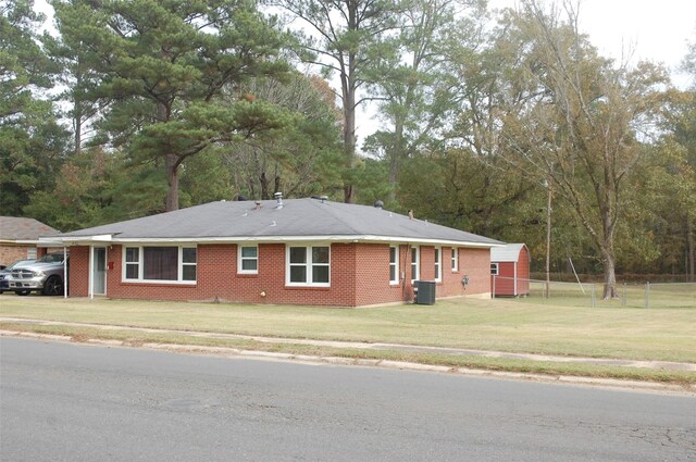 view of side of home with central AC and a yard