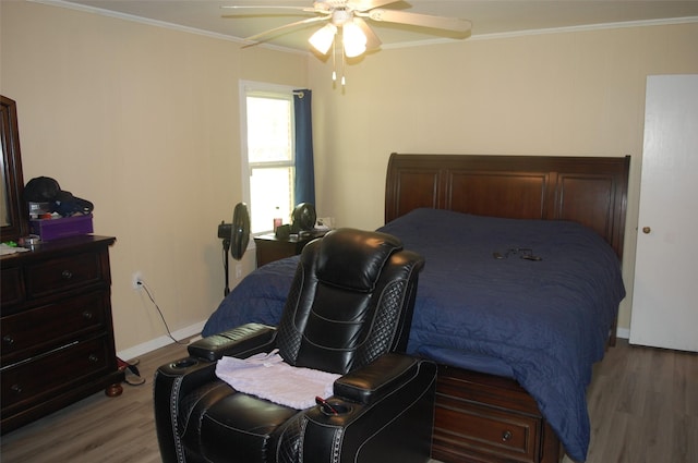 bedroom featuring hardwood / wood-style floors, crown molding, and ceiling fan