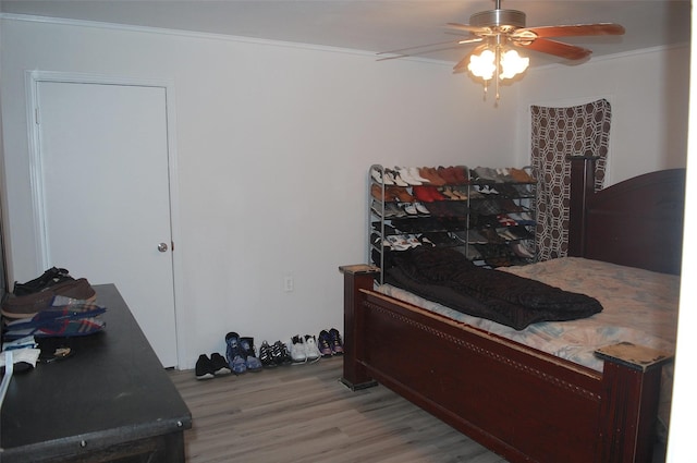 bedroom with crown molding, ceiling fan, and light hardwood / wood-style flooring