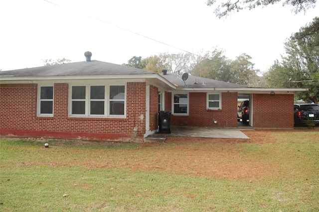 rear view of property featuring a lawn and a patio area