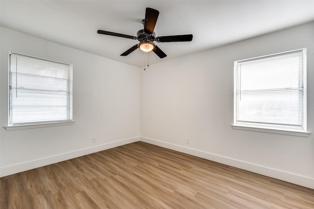 spare room with light hardwood / wood-style flooring, a wealth of natural light, and ceiling fan