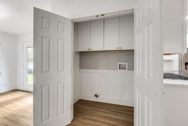 washroom with cabinets, hookup for a washing machine, and dark wood-type flooring