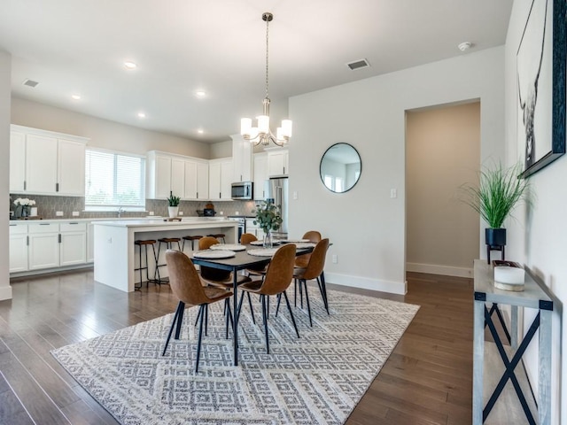 dining room with a notable chandelier and dark hardwood / wood-style floors