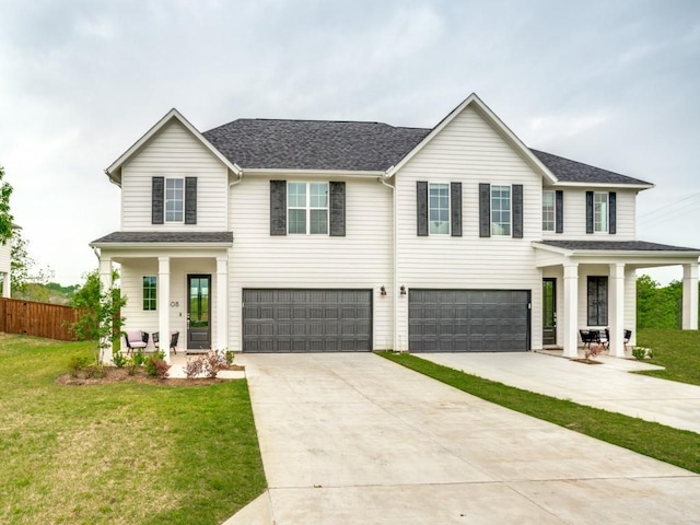 view of front of home with a garage, a porch, and a front lawn