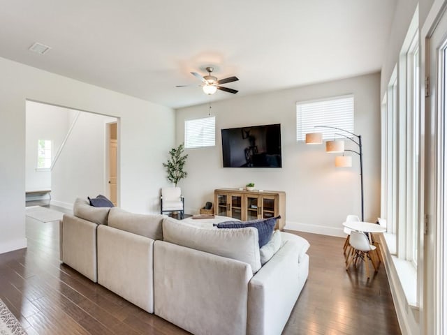 living room with ceiling fan and dark wood-type flooring