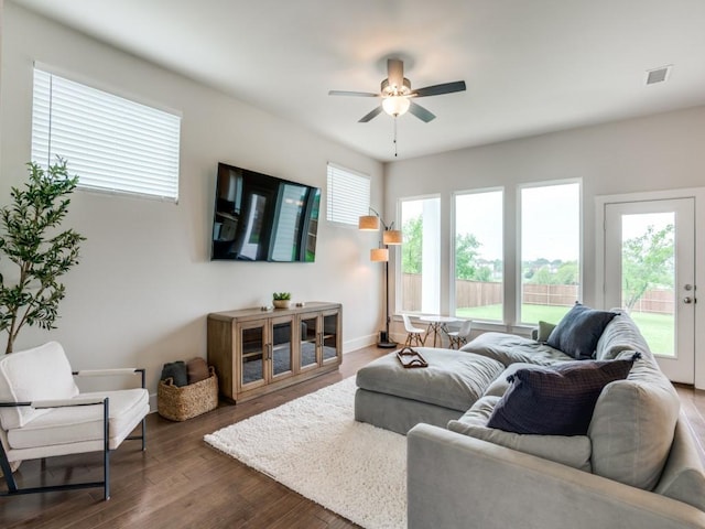 living room with ceiling fan, dark wood-type flooring, and a wealth of natural light