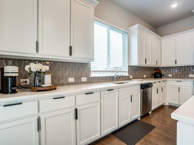 kitchen with white cabinetry, sink, stainless steel dishwasher, dark hardwood / wood-style floors, and backsplash