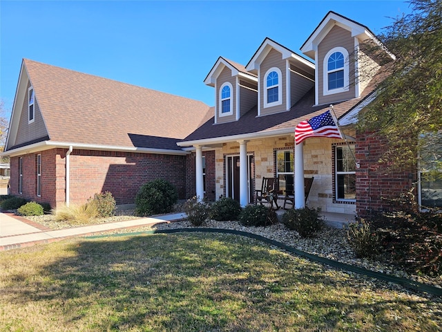 view of front facade featuring covered porch and a front yard