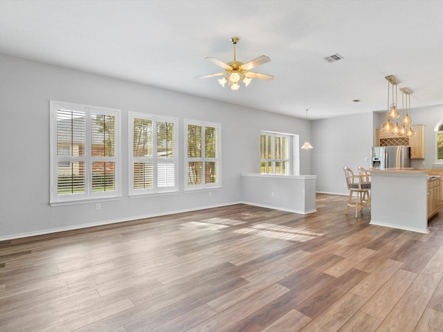 unfurnished living room featuring light hardwood / wood-style flooring and ceiling fan