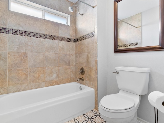 bathroom with tile patterned floors, toilet, and tiled shower / bath