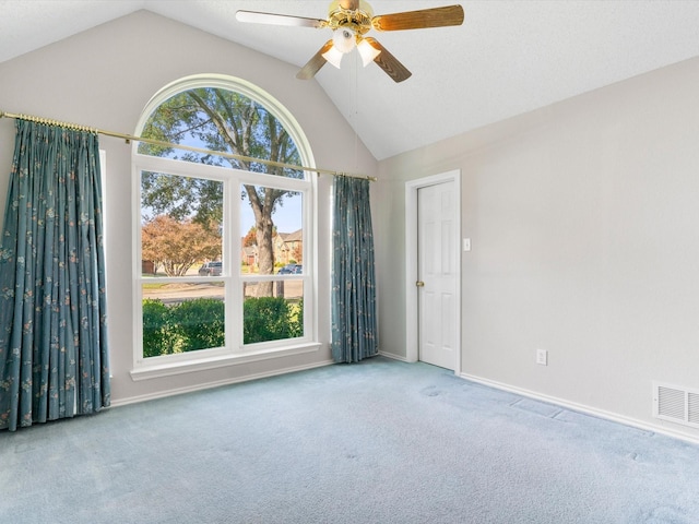 carpeted empty room featuring vaulted ceiling and ceiling fan