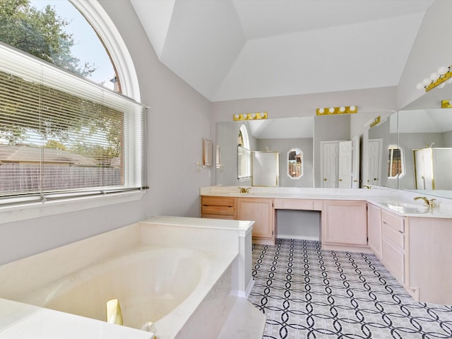 bathroom featuring a tub, vanity, and vaulted ceiling