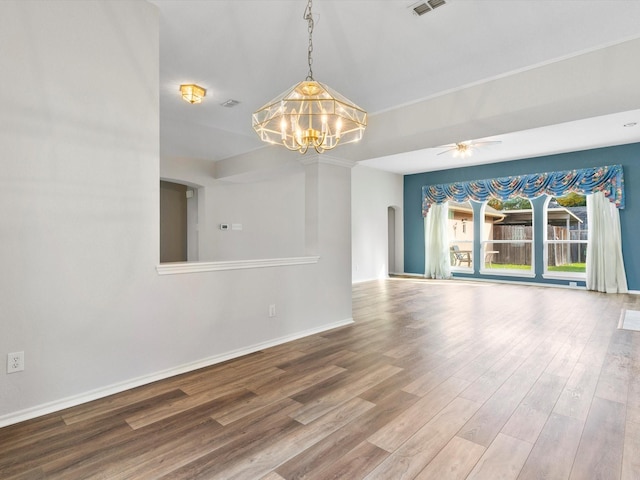 spare room with ceiling fan with notable chandelier and hardwood / wood-style flooring