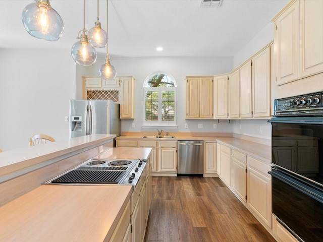 kitchen featuring decorative light fixtures, dark hardwood / wood-style floors, sink, and stainless steel appliances