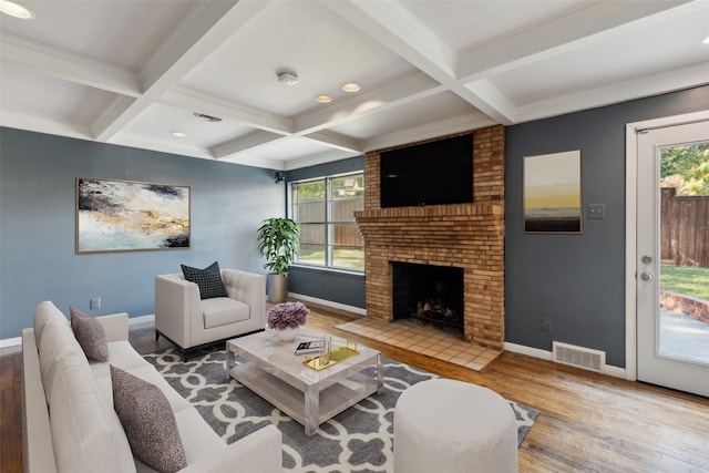 living room with beamed ceiling, wood-type flooring, coffered ceiling, and a brick fireplace