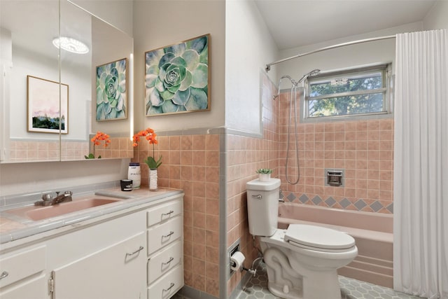 full bathroom featuring tiled shower / bath combo, tile patterned floors, toilet, vanity, and tile walls