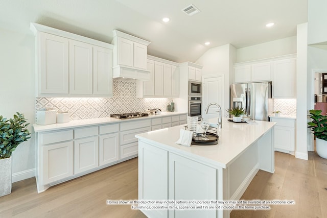 kitchen with decorative backsplash, light wood-type flooring, stainless steel appliances, and white cabinetry