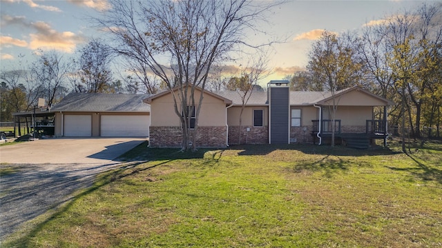 ranch-style house featuring a yard, a garage, and a porch