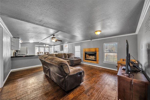 living room with a healthy amount of sunlight, dark hardwood / wood-style flooring, ornamental molding, and vaulted ceiling