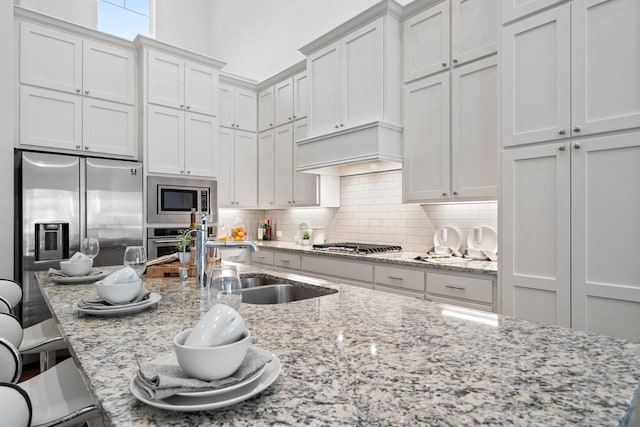 kitchen featuring white cabinets, a kitchen breakfast bar, sink, and appliances with stainless steel finishes