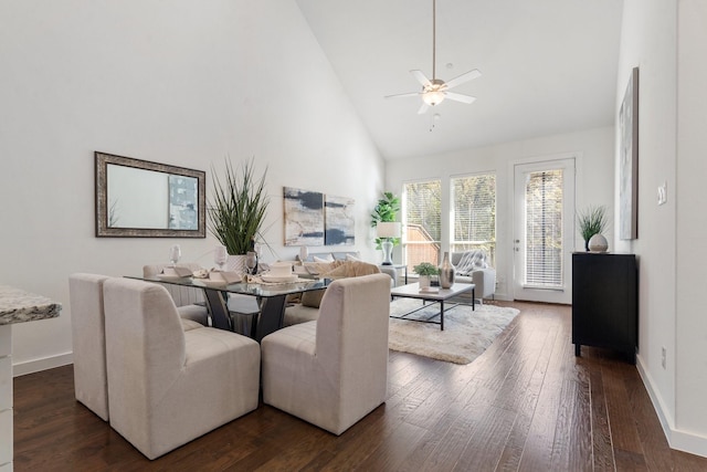 dining area with ceiling fan, high vaulted ceiling, and dark hardwood / wood-style floors