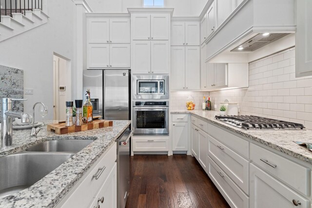 kitchen featuring custom range hood, stainless steel appliances, sink, white cabinets, and dark hardwood / wood-style floors