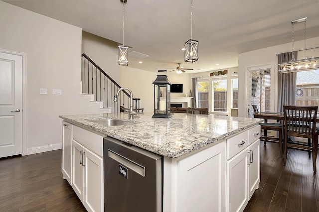 kitchen featuring white cabinets, dark hardwood / wood-style floors, a center island with sink, and sink