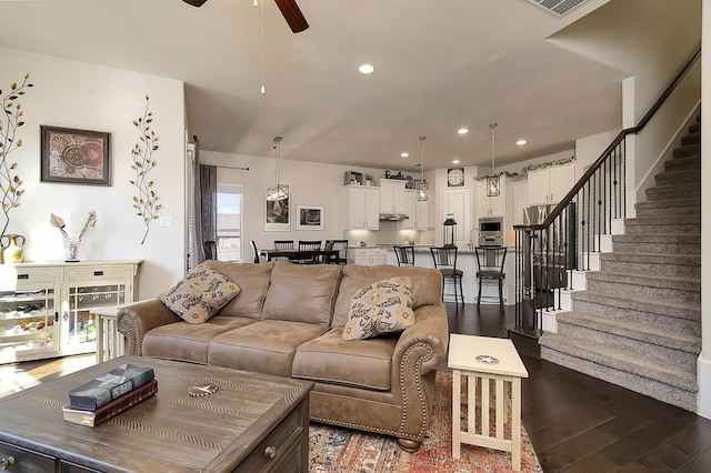 living room featuring ceiling fan and dark hardwood / wood-style flooring