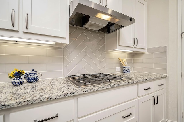 kitchen featuring decorative backsplash, white cabinetry, stainless steel gas cooktop, and light stone counters