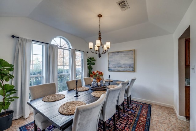 dining area featuring light tile patterned flooring, lofted ceiling, and an inviting chandelier