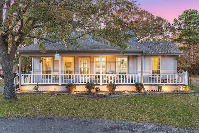 single story home with covered porch and a yard