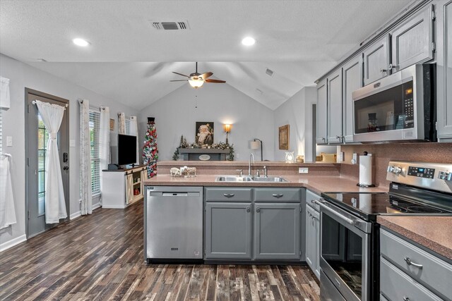 kitchen featuring gray cabinetry, sink, stainless steel appliances, and dark wood-type flooring